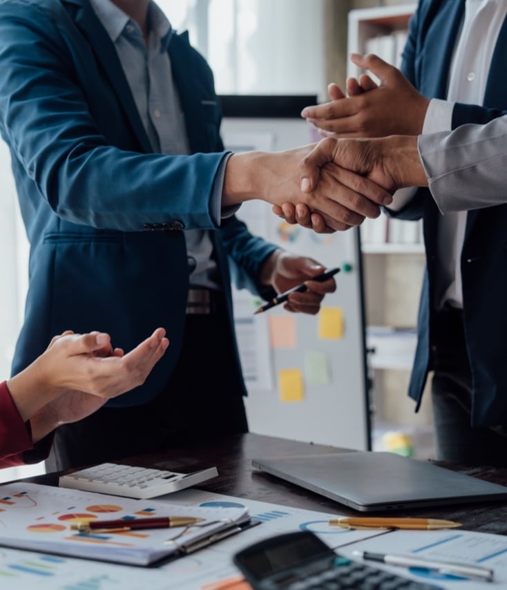 people shaking hands in modern office